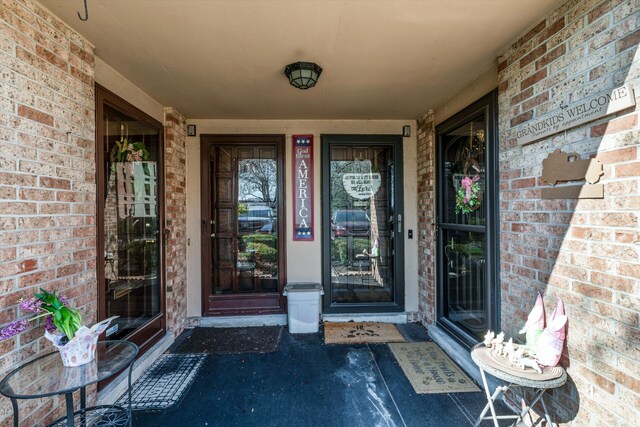 entrance to property featuring brick siding and a porch