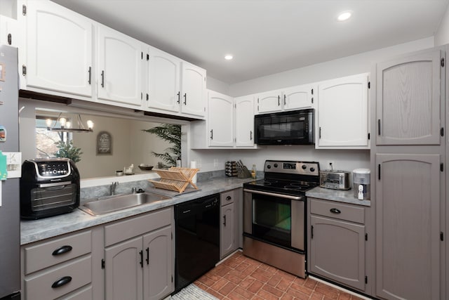 kitchen featuring light countertops, a sink, and black appliances