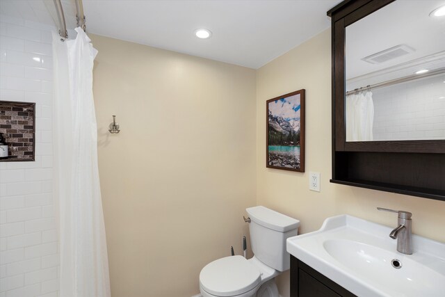 full bath featuring vanity, a tile shower, toilet, visible vents, and recessed lighting