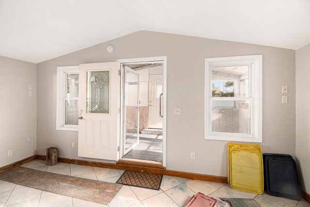 doorway with baseboards, tile patterned floors, and lofted ceiling