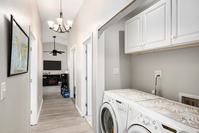 laundry area featuring cabinet space, washer and dryer, light wood-style floors, ceiling fan with notable chandelier, and baseboards