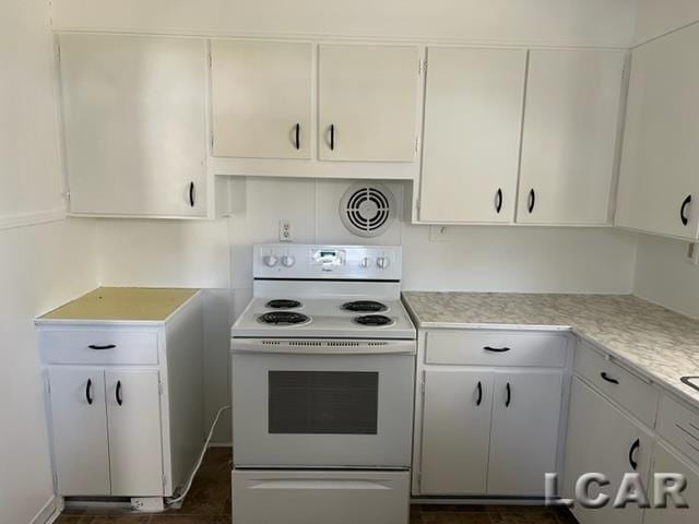 kitchen featuring white cabinets, light countertops, and electric stove