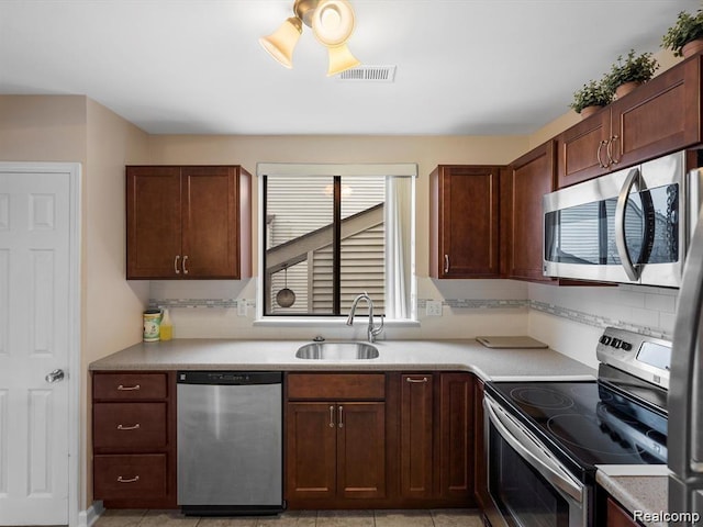 22161 Indian Creek Dr, Farmington Hills, MI 48335 - kitchen with appliances with stainless steel finishes, backsplash, and light countertops