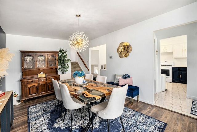 dining space featuring dark wood-style floors, an inviting chandelier, and stairs