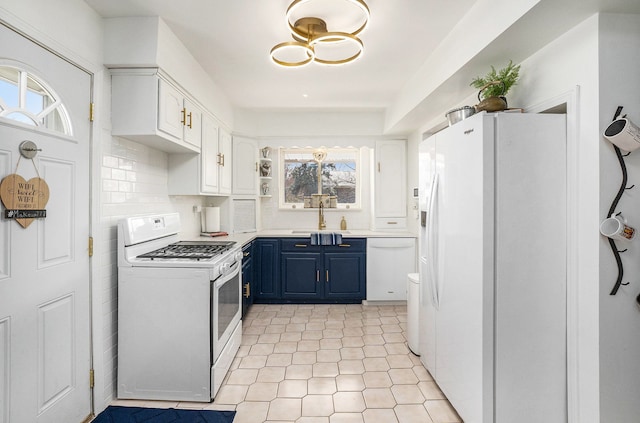 kitchen featuring blue cabinets, a sink, white cabinetry, white appliances, and light countertops