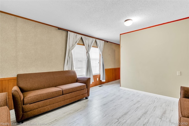 1822 Elizabeth Ter, Madison Heights, MI 48071 - living area with wood finished floors, a wainscoted wall, wood walls, crown molding, and a textured ceiling