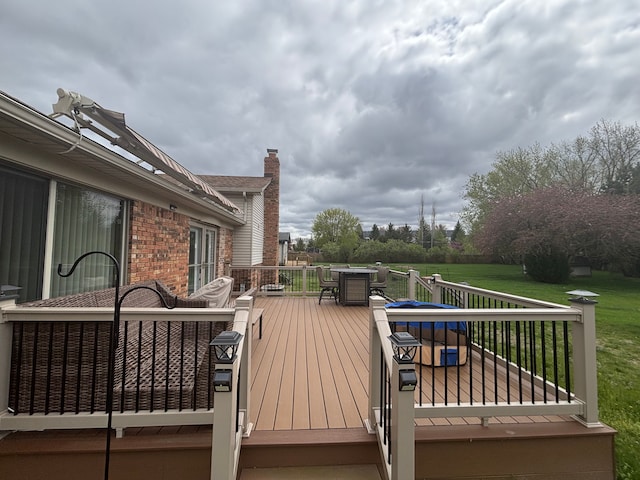 deck with a lawn and outdoor dining area