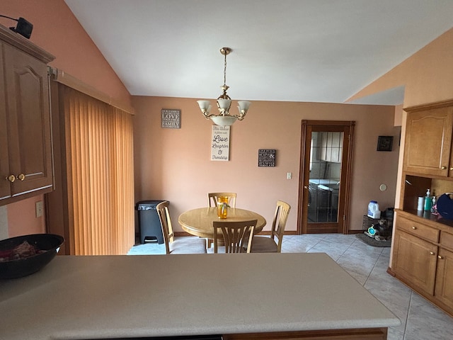 dining room with a chandelier, light tile patterned floors, and vaulted ceiling