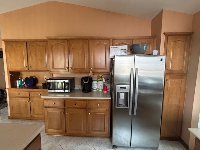 kitchen featuring lofted ceiling, brown cabinets, and stainless steel appliances