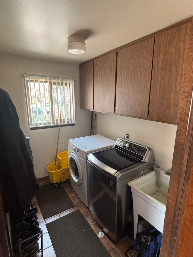 laundry room featuring a sink, cabinet space, tile patterned flooring, and independent washer and dryer