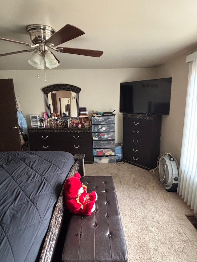 carpeted bedroom with visible vents and a ceiling fan