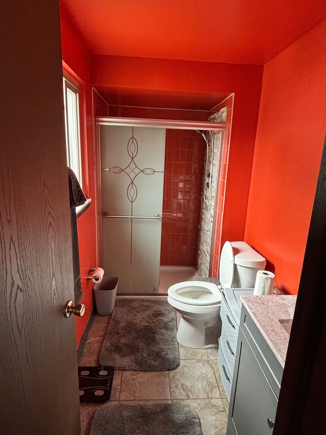 full bathroom featuring a shower stall, toilet, and vanity