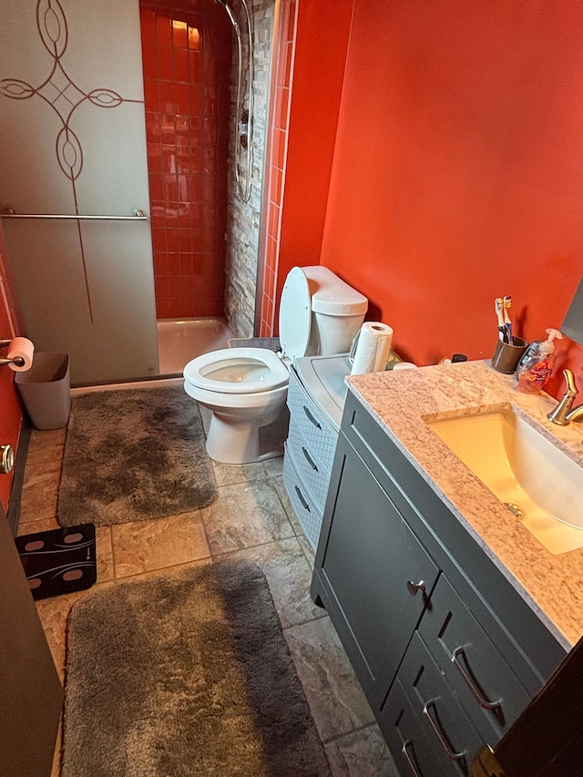 bathroom with toilet, vanity, and a shower stall