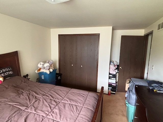 carpeted bedroom with visible vents and a closet