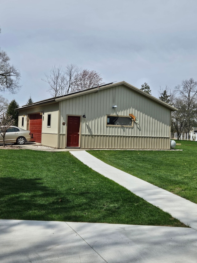 ranch-style home with an attached garage, board and batten siding, and a front yard