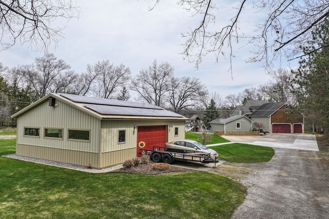view of home's exterior with a lawn, driveway, an outbuilding, and a garage