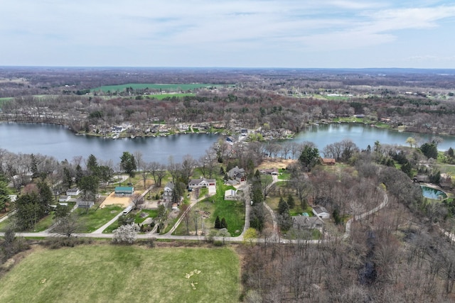drone / aerial view with a forest view and a water view