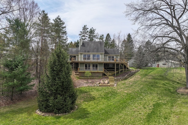 back of property featuring a wooden deck, a lawn, brick siding, and stairs