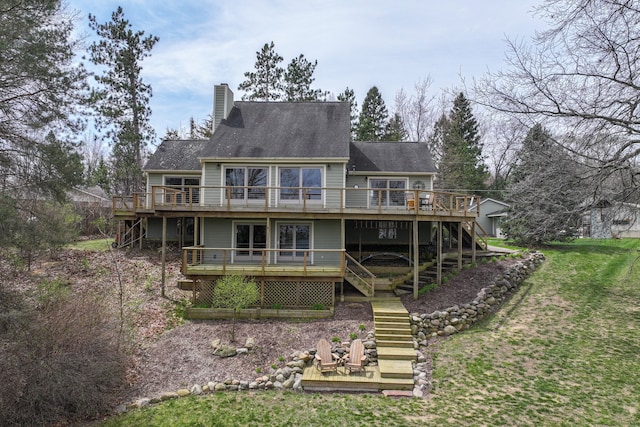 back of property with a chimney, stairway, a deck, and a lawn