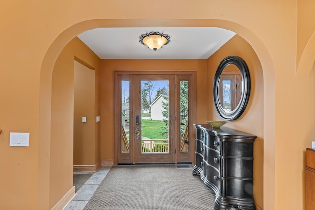 entrance foyer with arched walkways and baseboards