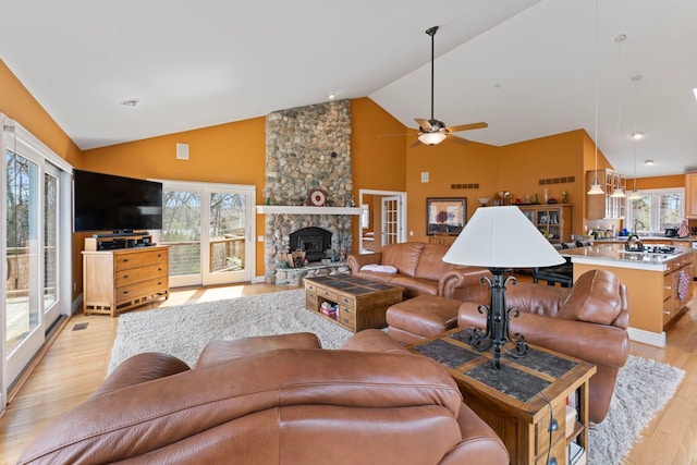 living area with plenty of natural light, ceiling fan, high vaulted ceiling, and light wood-type flooring