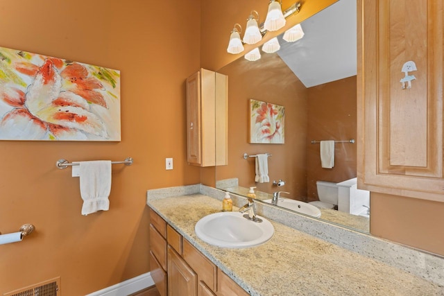 bathroom with toilet, visible vents, and vanity