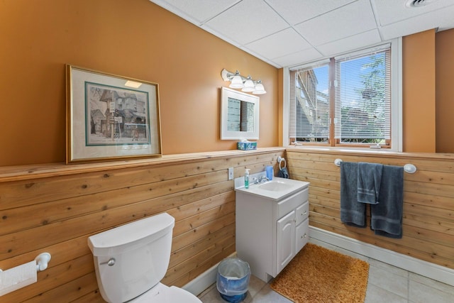 bathroom featuring a drop ceiling, vanity, toilet, and tile patterned floors