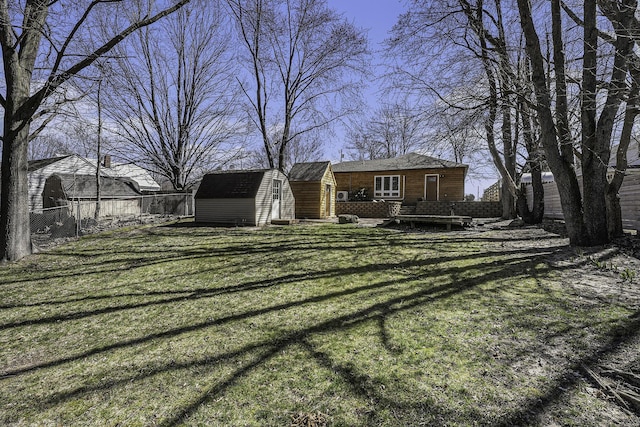 view of yard featuring a fenced backyard, a storage unit, and an outdoor structure