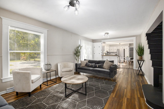 65 N Lake St, Grant, MI 49327 - living area featuring a wainscoted wall, baseboards, and dark wood-type flooring