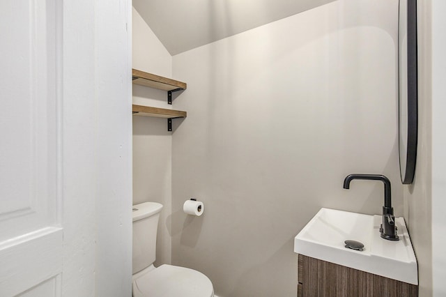 65 N Lake St, Grant, MI 49327 - bathroom with toilet, lofted ceiling, and vanity