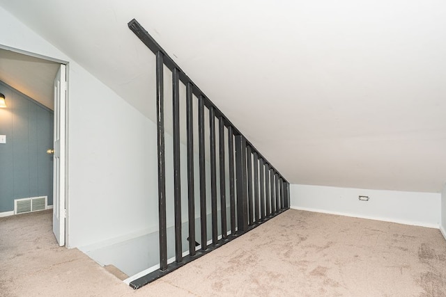 stairway with visible vents, carpet flooring, baseboards, and vaulted ceiling