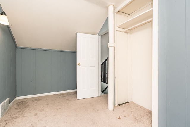 unfurnished bedroom featuring carpet floors, visible vents, and vaulted ceiling