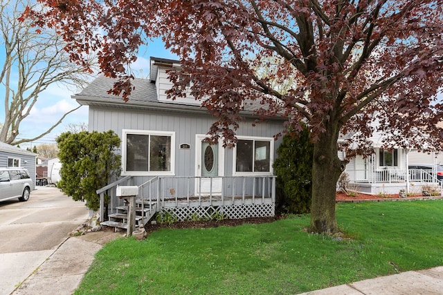 view of front of house featuring a shingled roof and a front yard