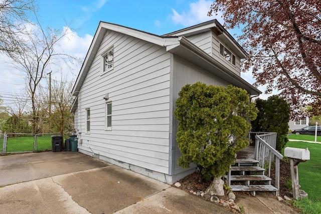 view of side of property featuring a lawn and fence