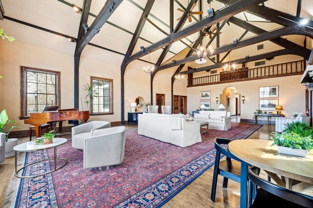 2801 Niles Buchanan Rd, Buchanan, MI 49107 - living room featuring wood finished floors, arched walkways, baseboards, high vaulted ceiling, and a notable chandelier