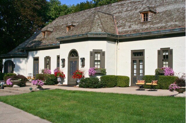 2801 Niles Buchanan Rd, Buchanan, MI 49107 - view of front facade with stucco siding, a high end roof, a front yard, and french doors