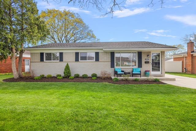 ranch-style home with brick siding, fence, and a front lawn