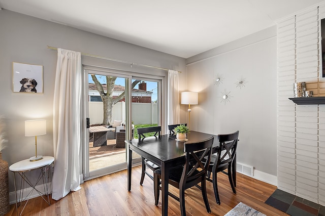 dining room featuring wood finished floors, visible vents, and baseboards