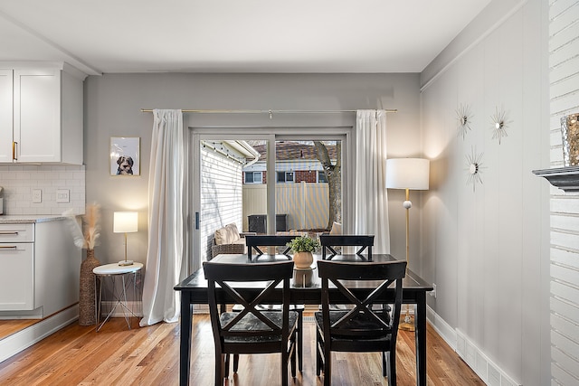 dining area featuring visible vents, light wood-style flooring, and baseboards