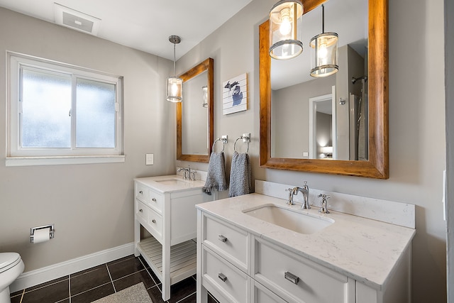 full bathroom featuring two vanities, visible vents, baseboards, and a sink