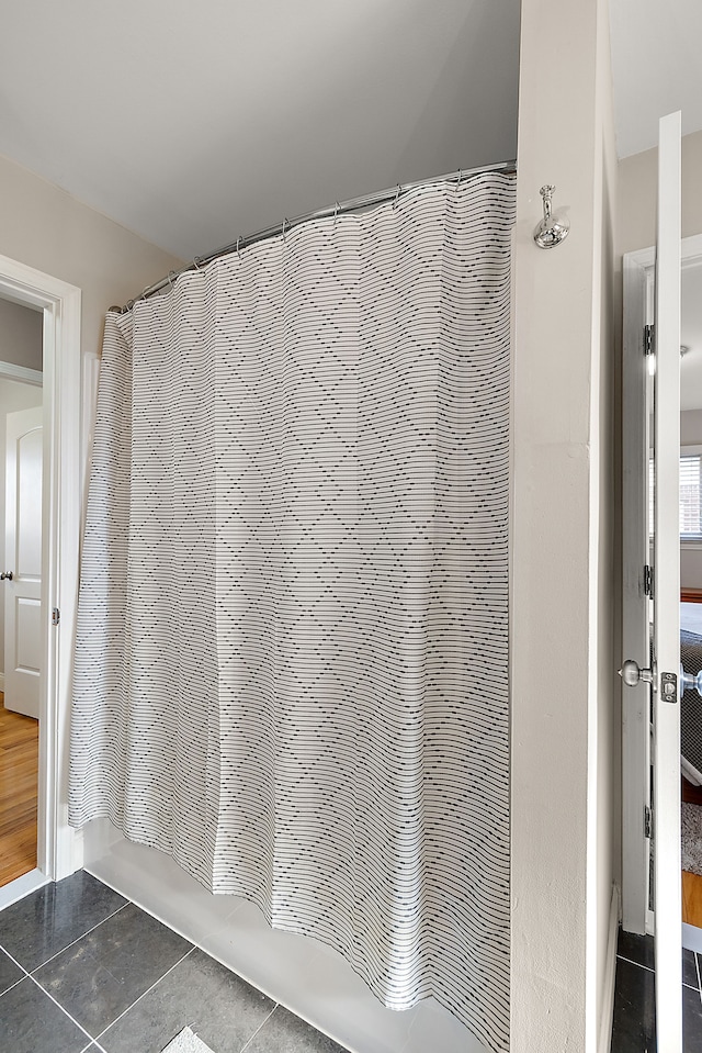 bathroom featuring shower / tub combo and tile patterned flooring