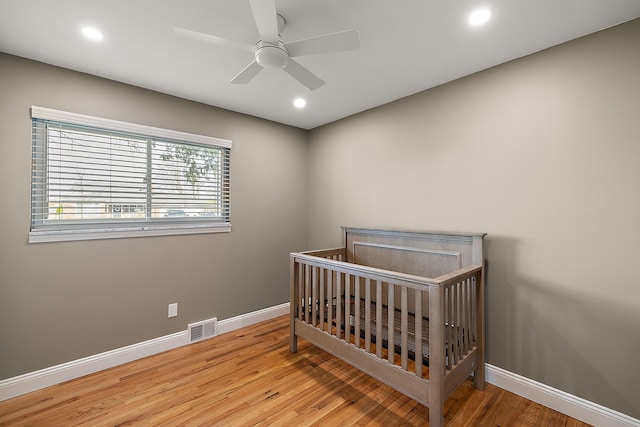 bedroom featuring wood finished floors, visible vents, recessed lighting, and baseboards