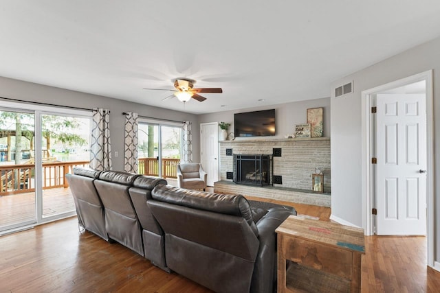 16191 Seymour Rd, Argentine, MI 48451 - living room featuring a ceiling fan, a brick fireplace, wood finished floors, and baseboards