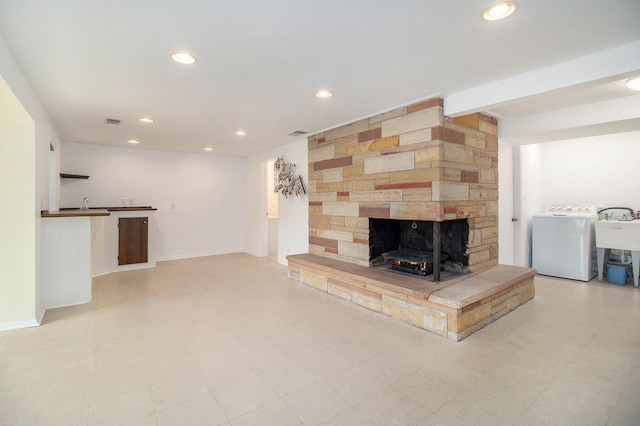 unfurnished living room featuring a fireplace, visible vents, recessed lighting, and washer / clothes dryer