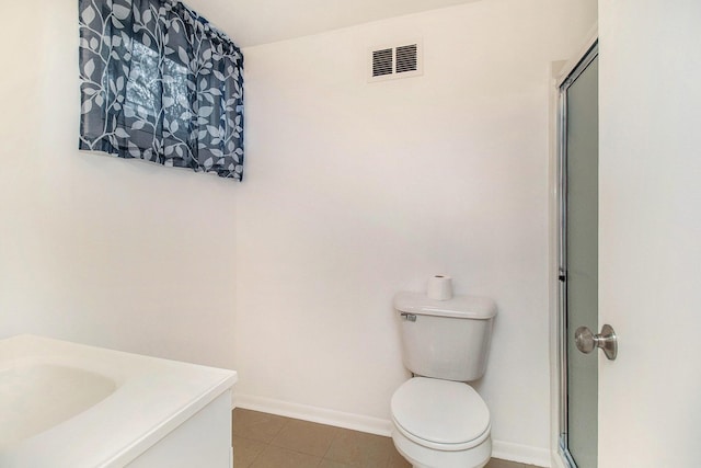 bathroom featuring tile patterned flooring, visible vents, an enclosed shower, toilet, and baseboards