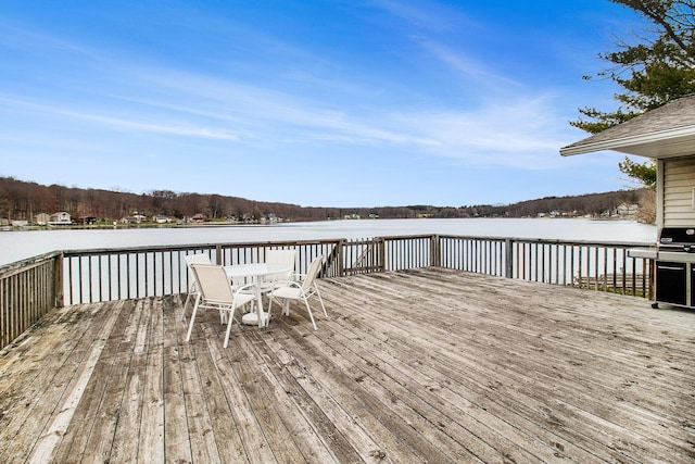 wooden deck featuring outdoor dining area and a grill