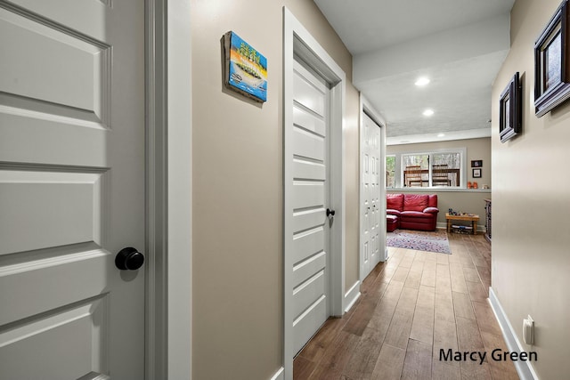 hallway with baseboards, wood finished floors, and recessed lighting