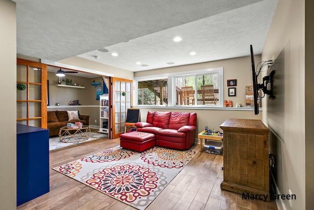 living room with recessed lighting, wood finished floors, and a textured ceiling