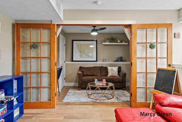 living area with wood finished floors, visible vents, and ceiling fan