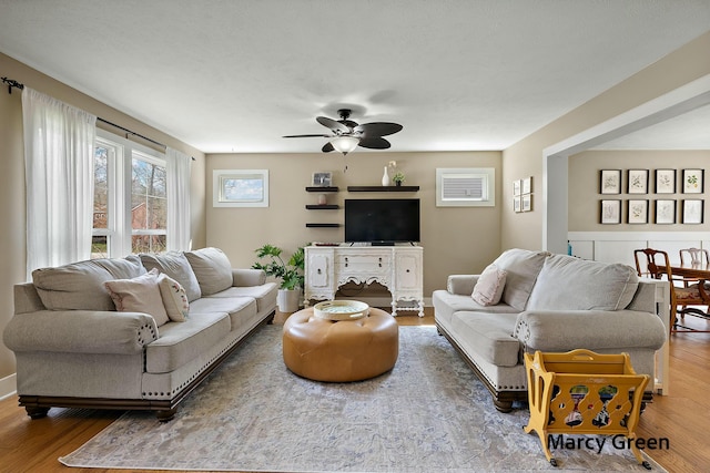 living area with a ceiling fan and wood finished floors